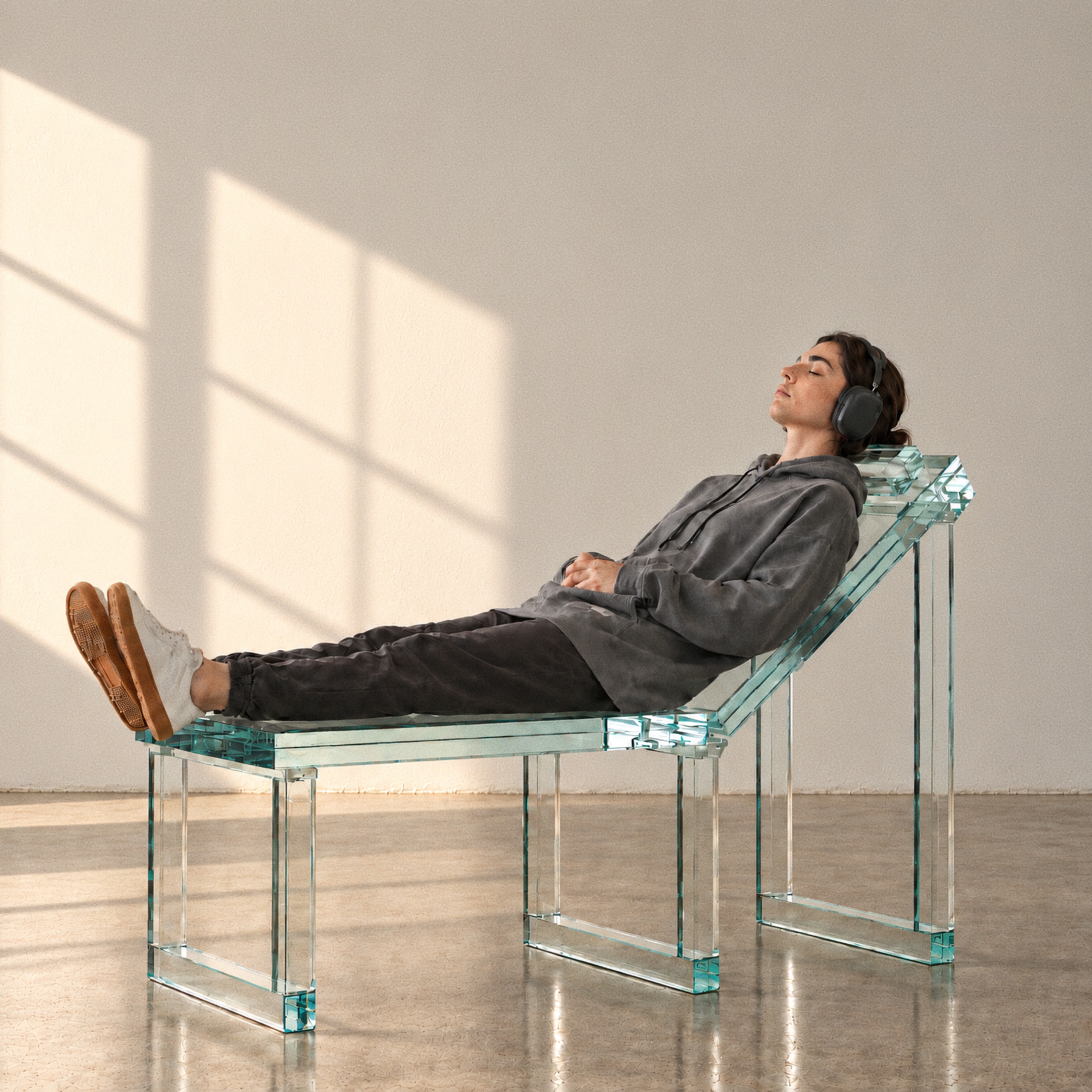 Therapy (2026 Remaster) cover: a person wearing headphones reclining on a glass chair in sunlight